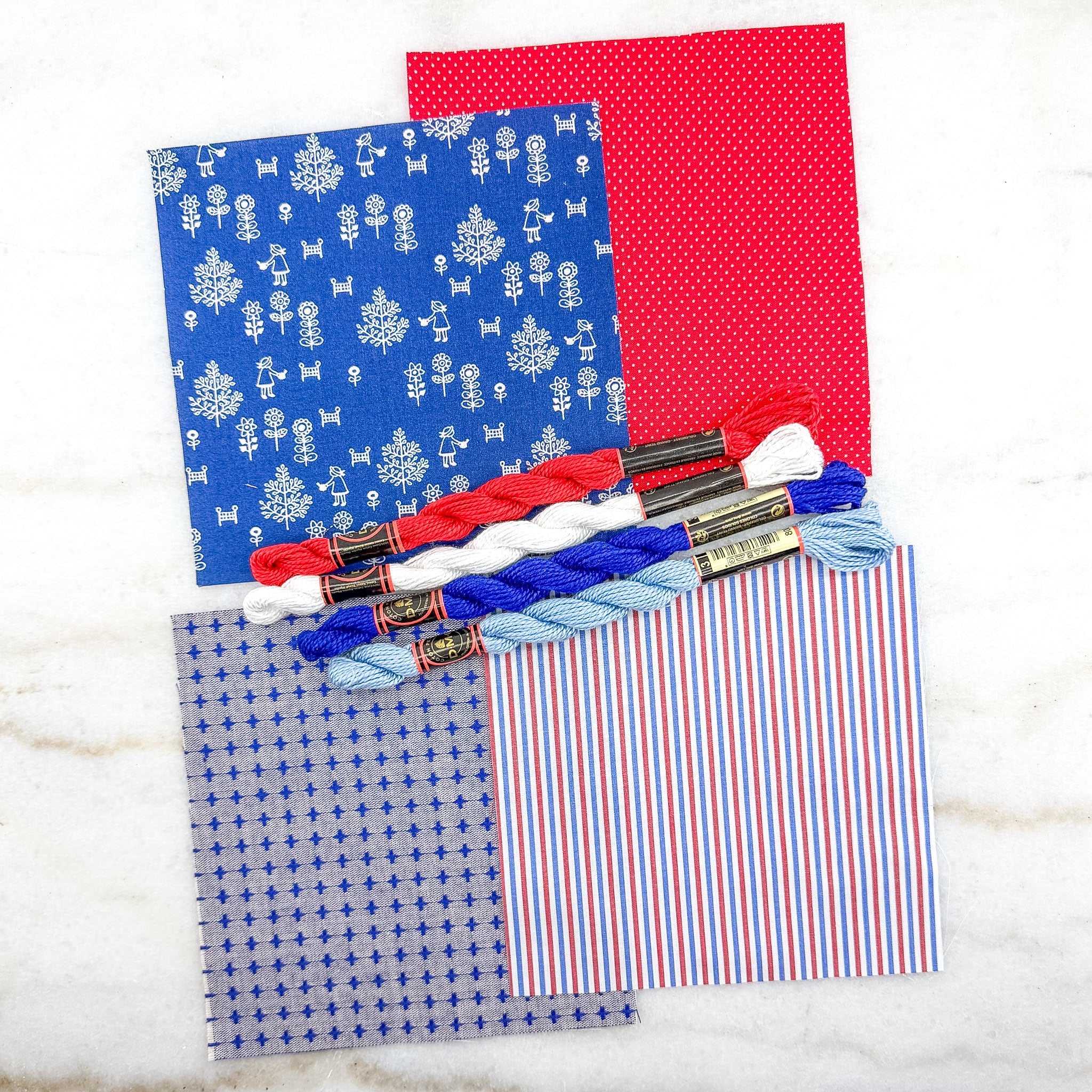 Colorful fabric samples with embroidery floss on a white background