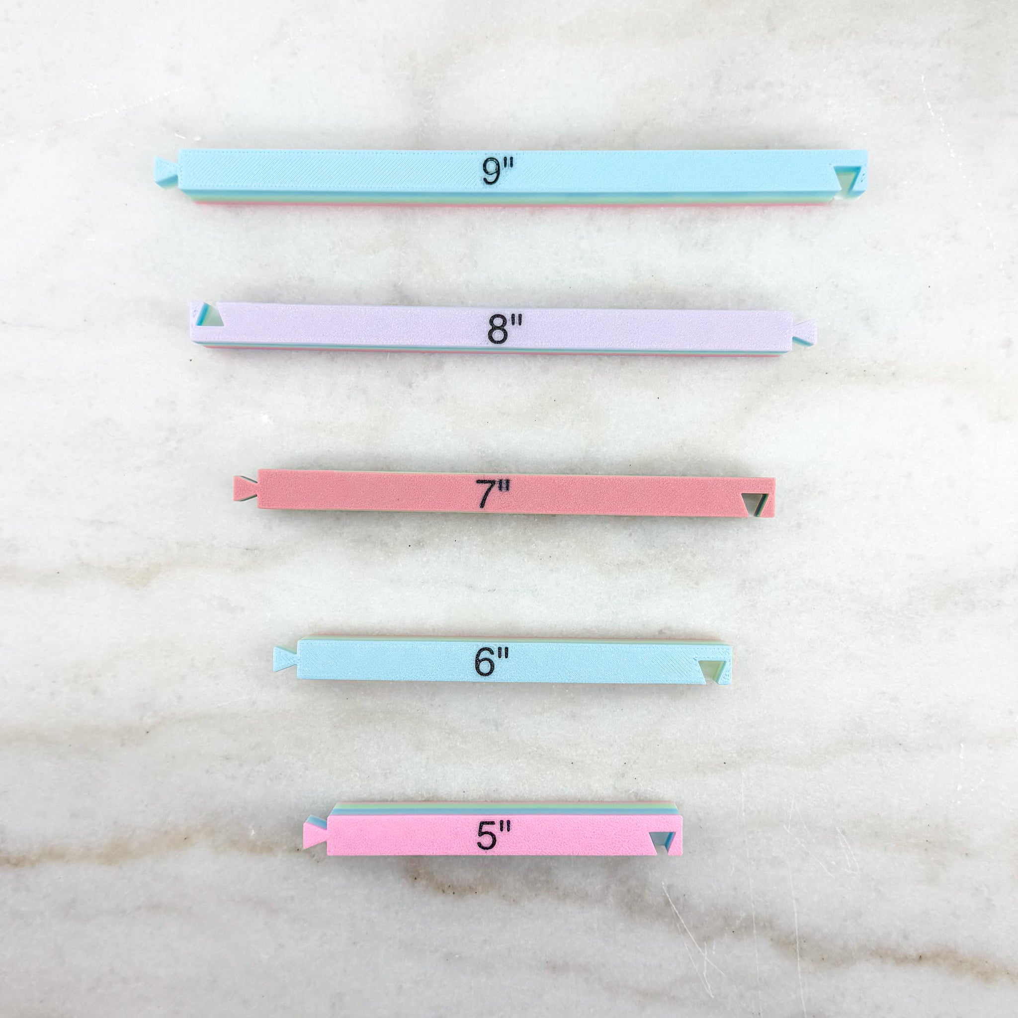 Set of colorful rulers with measurements on a marble surface