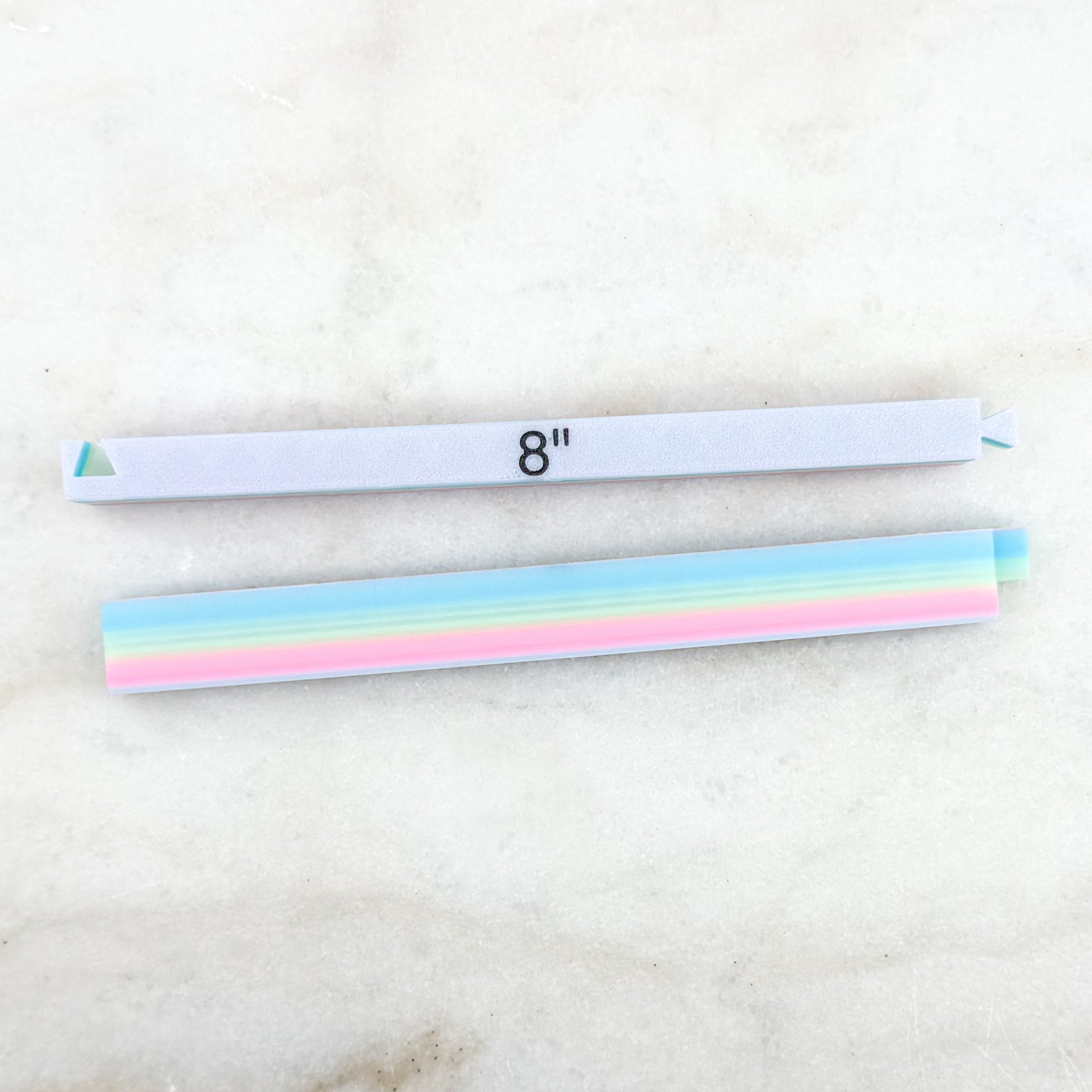 Two headbands, one plain white and one with colorful stripes, on a light background.