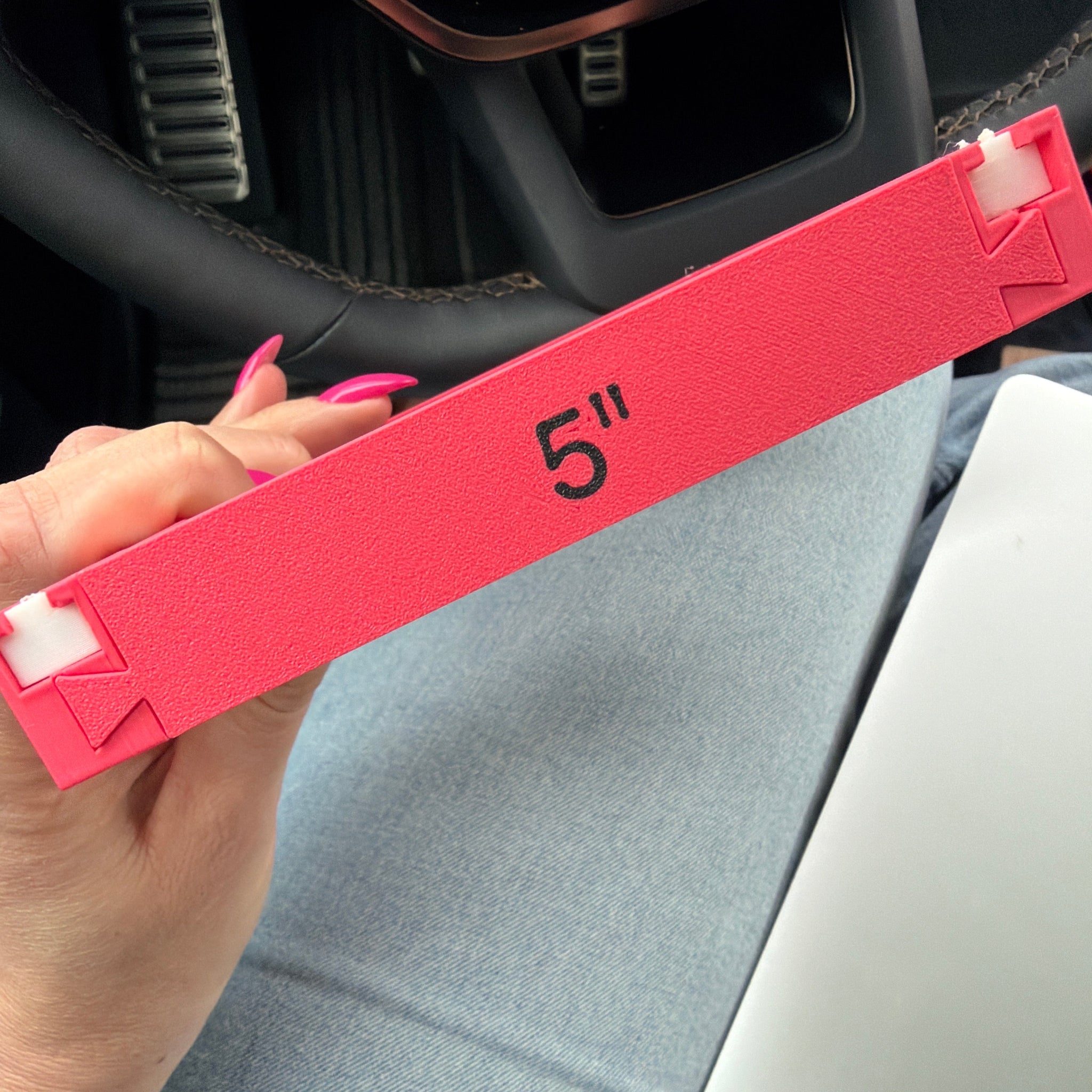 Red tool box with 'S' logo held by a hand inside a car.