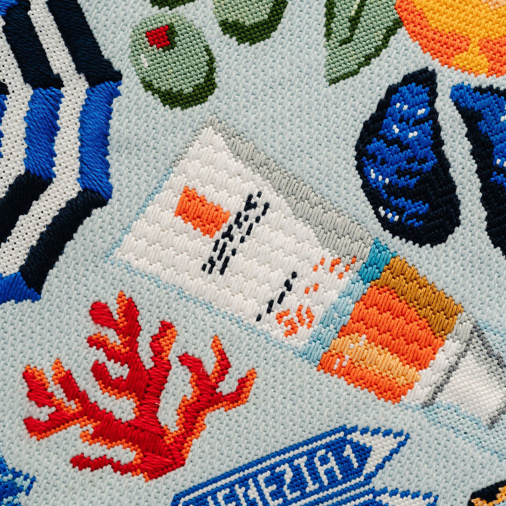 Embroidered design with travel-themed elements on a fabric background