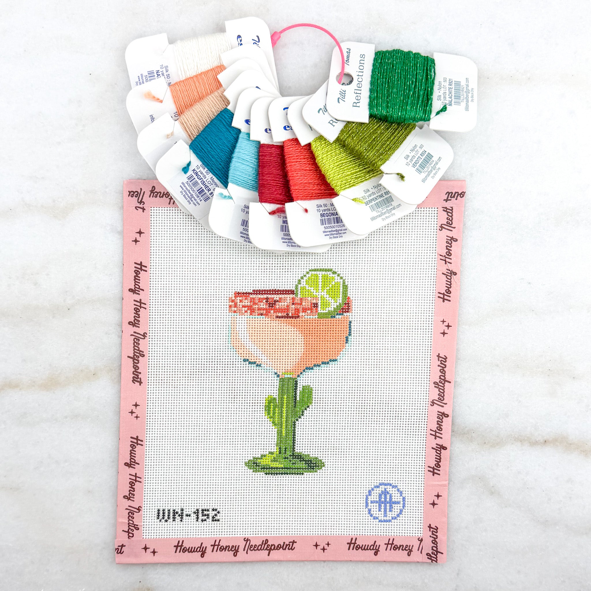 Color swatch card with cross-stitch thread samples and a cactus-themed cross-stitch design on a white background.