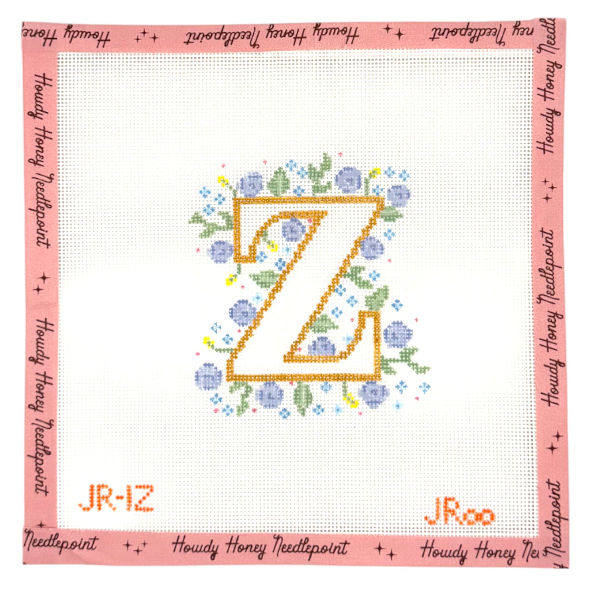 Cross-stitched letter 'Z' with flowers on a white background, framed by pink border with text.