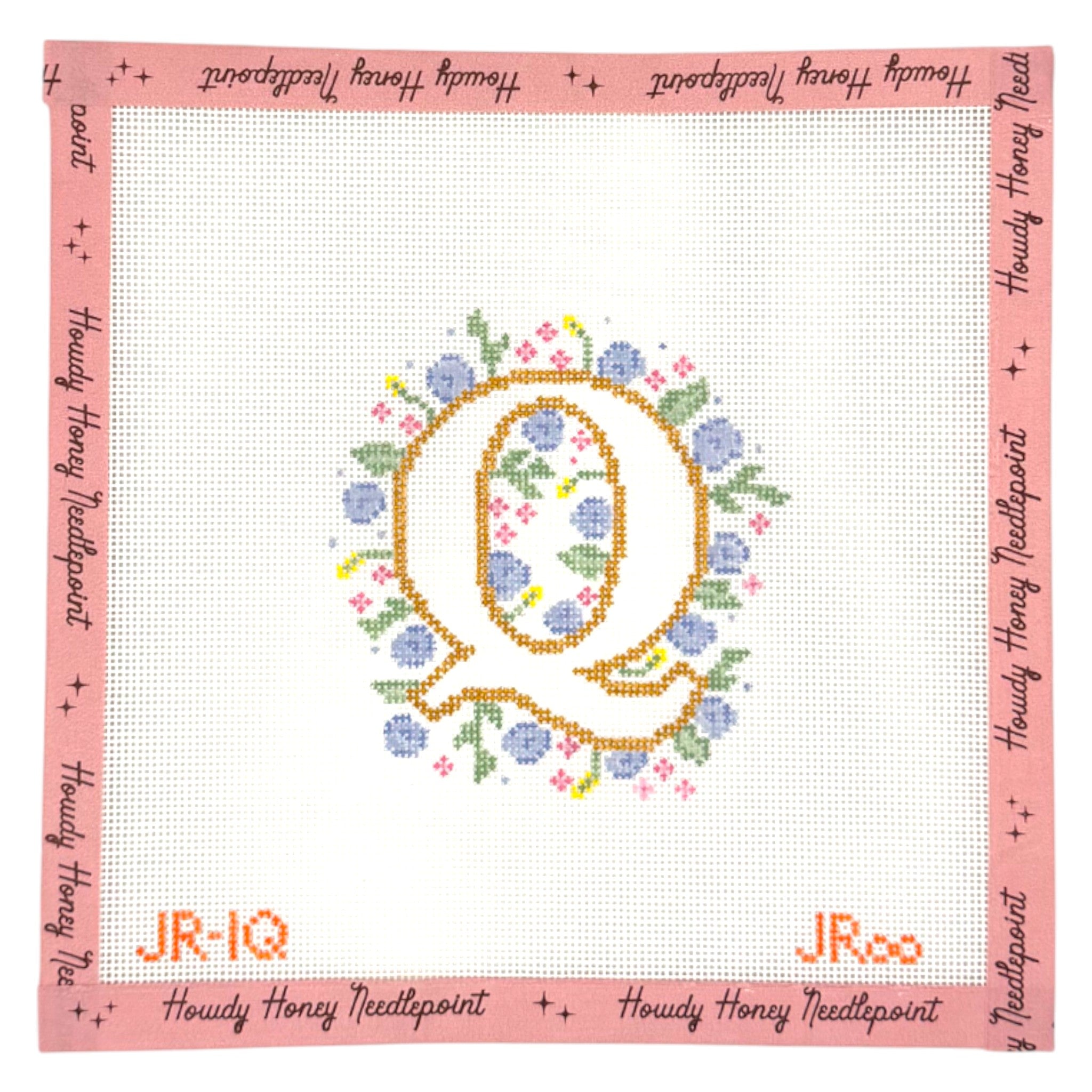 Embroidery hoop with floral design and 'Howdy Honey Needlepoint' branding on a pink border.
