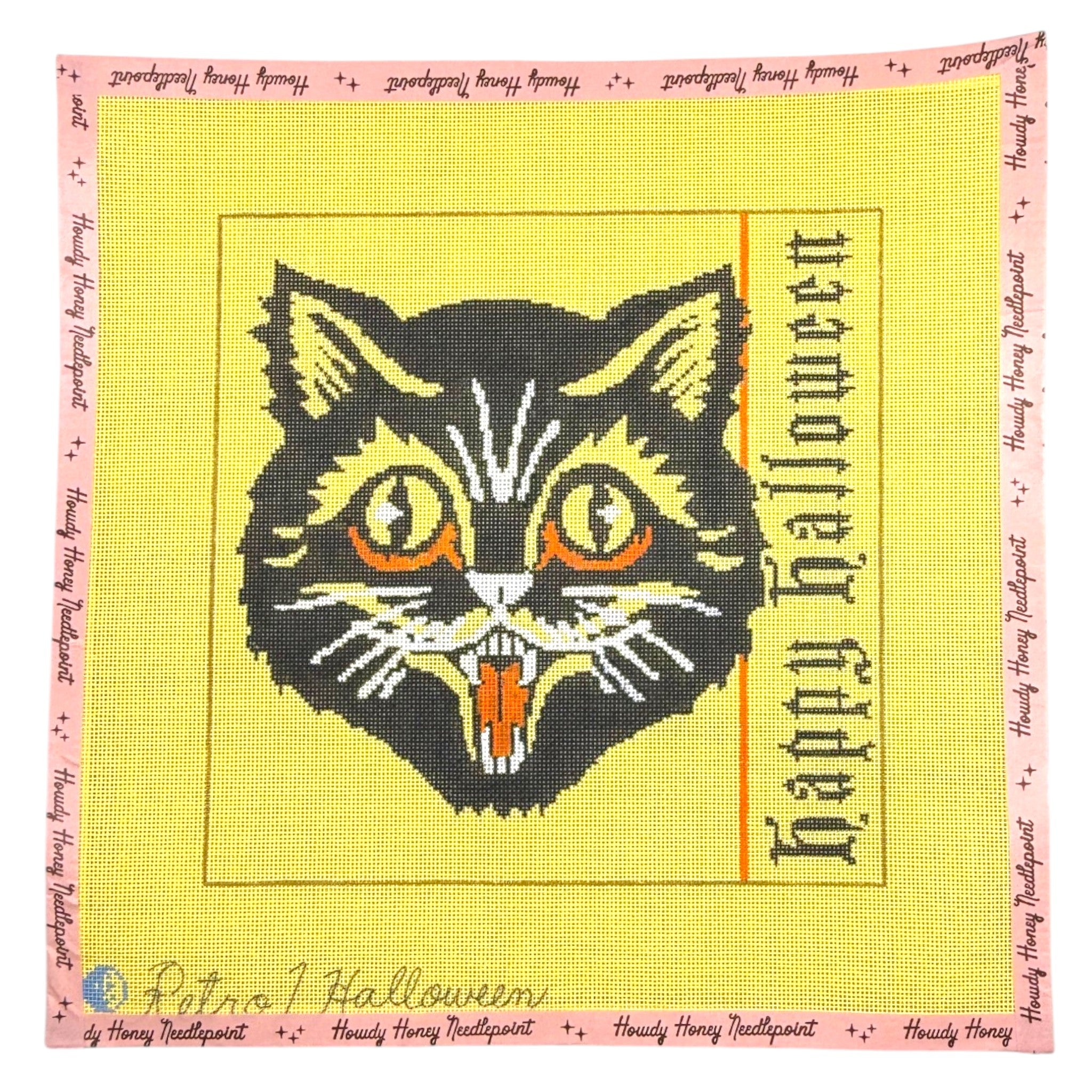Halloween-themed needlepoint with a cat design and 'Happy Halloween' text on a yellow background.