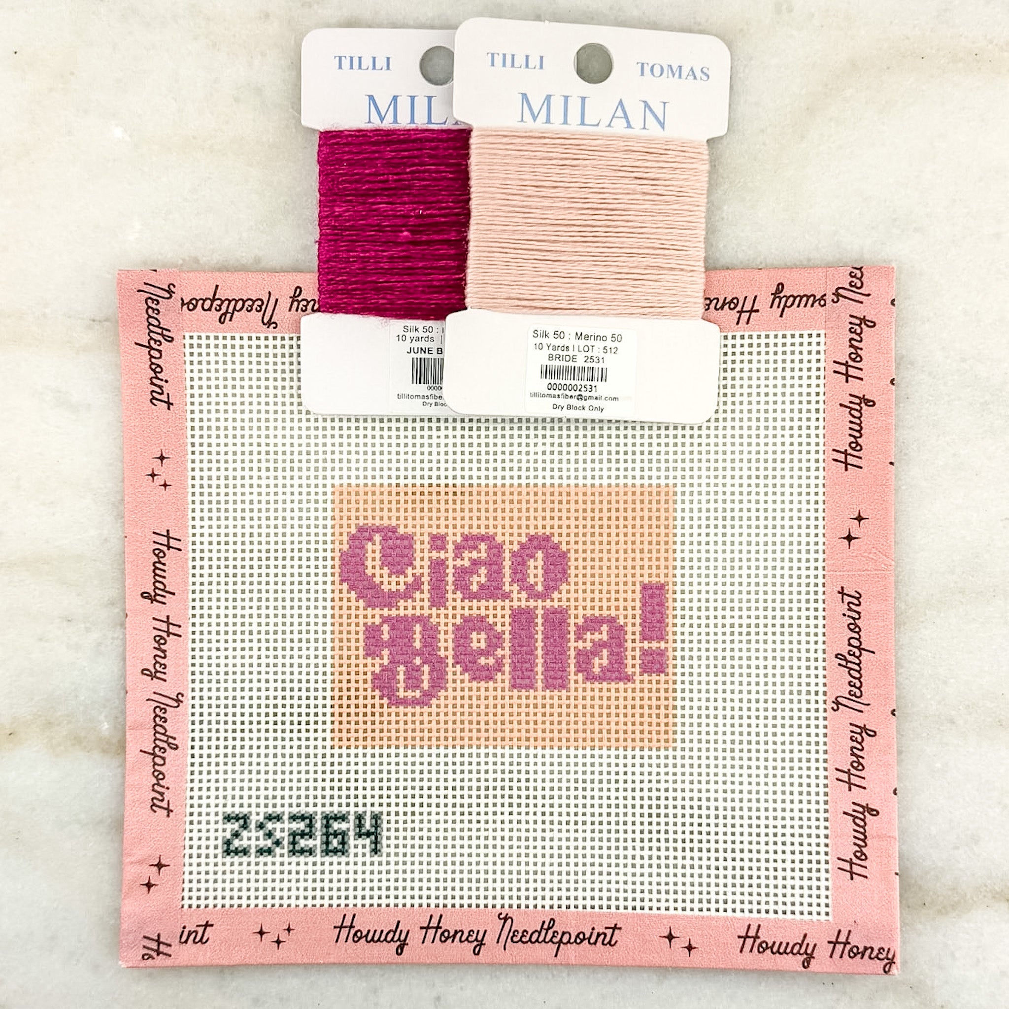 Cross-stitch kit with 'Ciao Bella' text and two skeins of yarn on a white background
