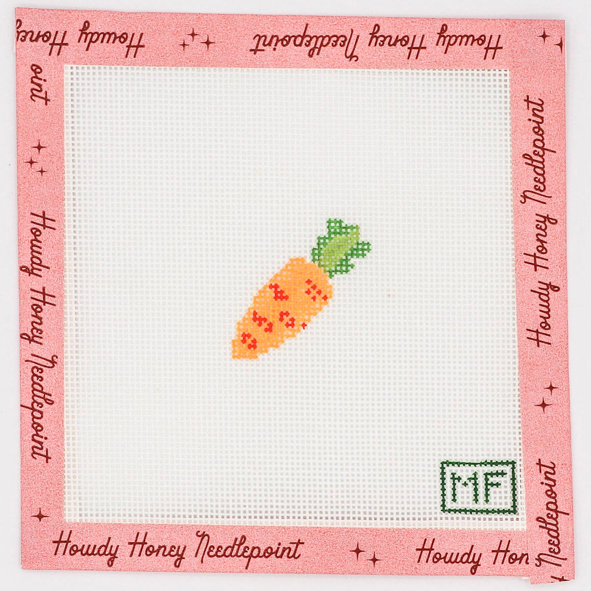 A needlecraft kit with a design of a carrot on a white canvas, surrounded by a pink border with text, and the initials 'MF' in the bottom right corner.
