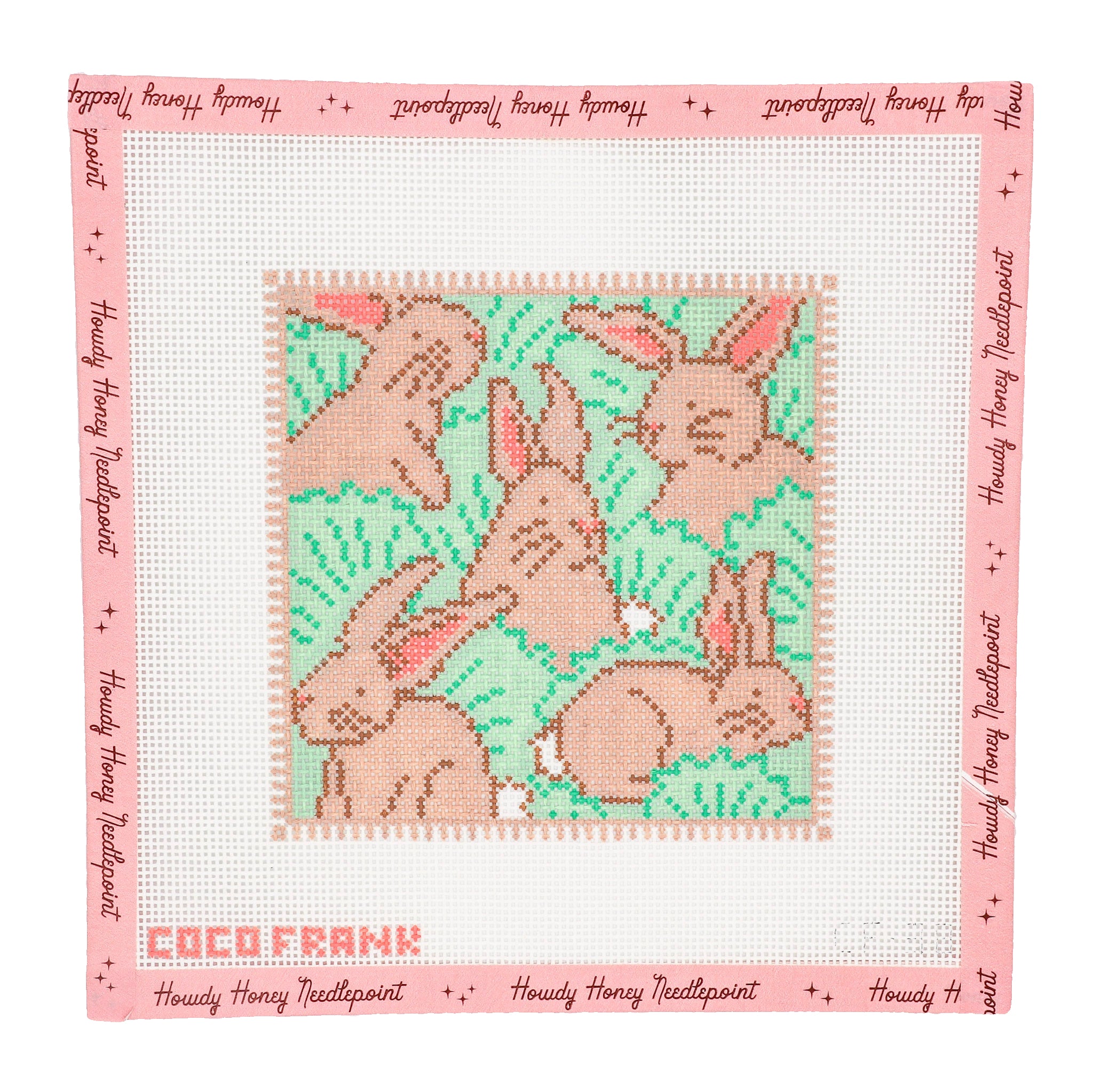 Cross-stitched pattern of bunnies on fabric with 'Coco Frank' branding.