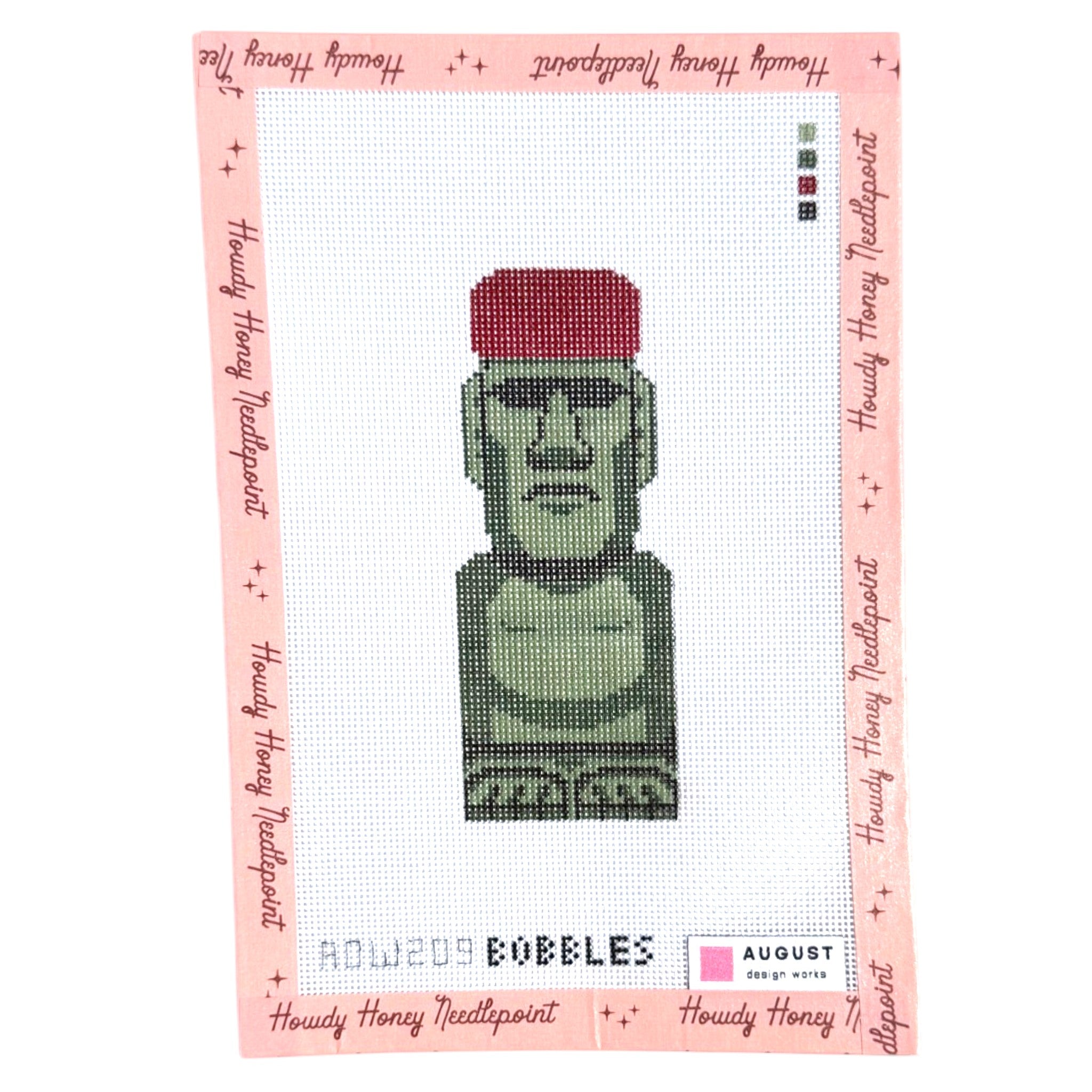 Cross-stitched design of a green character with a red hat on a pink border with text